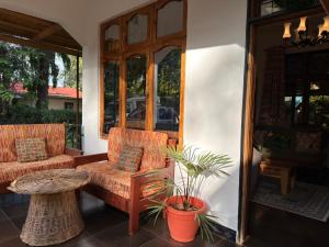 a porch with two chairs and a couch and a table at Sophie Homestay in Moshi