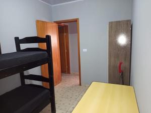 a room with two bunk beds and a yellow table at Trabalhamos com casas e alojamentos para empresas in Cianorte