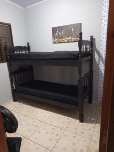 a dark wooden bunk bed in a room at Trabalhamos com casas e alojamentos para empresas in Cianorte