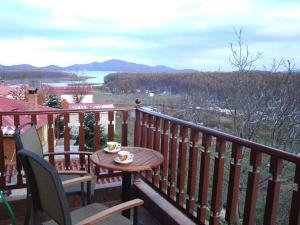 a table and chairs on a balcony with a coffee cup at Akrolimnia in Kalyvia +25 photos