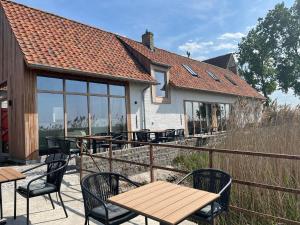 a patio with tables and chairs and a house at Hoeve De Hemel in Zuienkerke