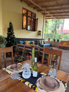 a table with a bottle of wine and a christmas tree at Sophie Homestay in Moshi +68 photos