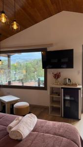 a bedroom with a bed and a large window at Vimaen Suites in La Cumbrecita