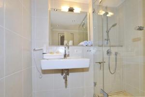 a bathroom with a sink and a shower at Malvenhof, App OG in Wenningstedt