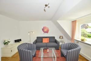 a living room with a couch and two chairs at Malvenhof, App OG in Wenningstedt