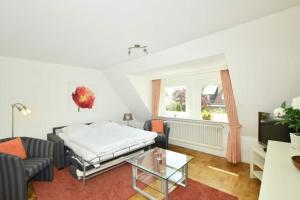 a living room with a bed and a couch at Malvenhof, App OG in Wenningstedt