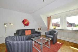 a living room with two couches and a glass table at Malvenhof, App OG in Wenningstedt +15 photos