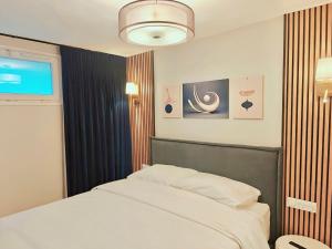 a bedroom with a white bed and a window at SCI Gomis Invest in Issy-les-Moulineaux +22 photos