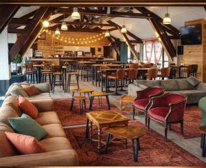 a restaurant with couches and tables and a bar at Village Montanha Lioran in Saint-Jacques-des-Blats