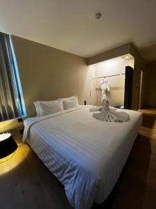 a large white bed in a room with a window at Bubble Humble Bangkok By Canal in Bangkok