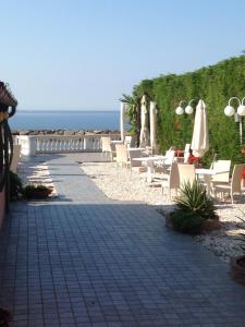 un patio con sillas y sombrillas y el océano en Casa Vacanze SanGiacomo, en Santo Stefano al Mare