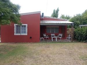 a red house with chairs and a patio at En Santa Rosa in Santa Rosa