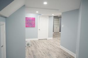 an empty room with white walls and a painting on the wall at Luxury 5BR Home with Spa Bath in Burlington