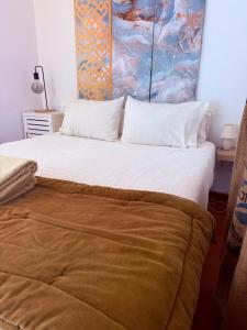 a bedroom with a large bed with a large white bedspread at Zambujeira Lounge in Zambujeira do Mar