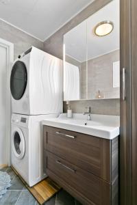 a bathroom with a washing machine and a sink at Centrum apartment 1 in Ålesund +15 photos