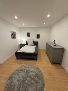 a bedroom with a bed and a dresser in a room at Work & Sleep Am Waldesrand in Vollersode