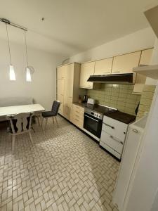 a kitchen with white cabinets and a table in it at Work & Sleep Am Waldesrand in Vollersode +35 photos