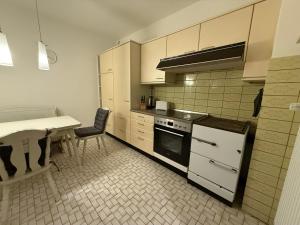 a kitchen with white cabinets and a table and a stove at Work & Sleep Am Waldesrand in Vollersode