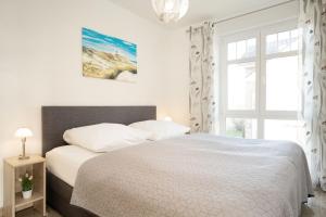 a bedroom with a white bed and a window at Bürgermeister-Fox 42a Meer-Blick in Fehmarn
