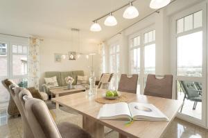 a dining room with a table with books and chairs at Bürgermeister-Fox 42a Meer-Blick in Fehmarn
