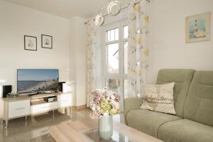 a living room with a couch and a tv at Bürgermeister-Fox 42a Meer-Blick in Fehmarn