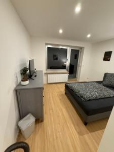 a bedroom with a bed and a desk and a television at Work & Sleep Am Waldesrand in Vollersode