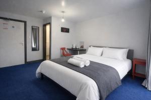 a bedroom with a large bed with two rolled towels on it at BEST DEAL - Kings Hotel in Blackburn