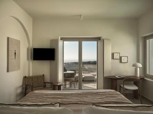 a bedroom with a bed and a sliding glass door at Ark in Pyrgos