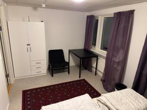 a bedroom with a desk and a bed and a chair at Frövi vandrarhem in Frövi
