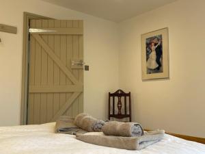a bedroom with a bed and a door with a picture at Escape to Blacksmiths Cottage in Cuckfield