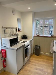 a kitchen with a microwave and a stove top oven at Escape to Blacksmiths Cottage in Cuckfield
