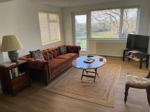 a living room with a couch and a coffee table at Escape to Blacksmiths Cottage in Cuckfield