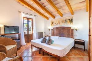 a bedroom with a large bed and a tv at Agroturismo Sa Vall by MHR in Son Macia