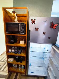 a refrigerator with a microwave and butterflies on the wall at Alojamiento en Tlaxco in Tlaxco de Morelos