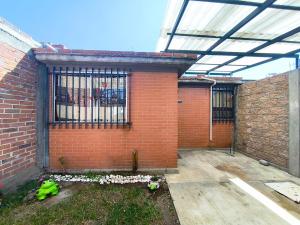 a brick building with a window and a fence at Alojamiento en Tlaxco in Tlaxco de Morelos