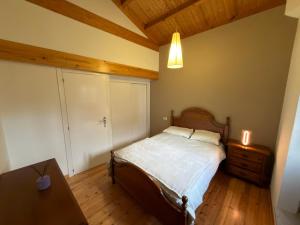 a bedroom with a bed and a table with a candle at A Casa de Feli in Muros