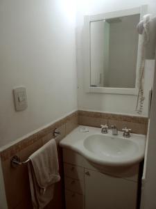 a bathroom with a sink and a mirror at Suites Piltri in El Bolsón