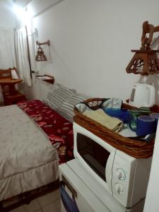a bedroom with a microwave on top of a bed at Suites Piltri in El Bolsón +2 photos