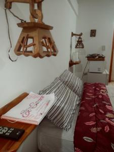 a bedroom with a bed and a table with a book at Suites Piltri in El Bolsón