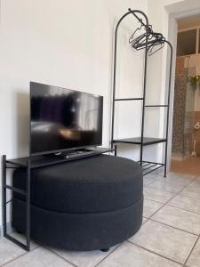 a tv sitting on top of a black ottoman at Un mondo in pianura in Turano Lodigiano