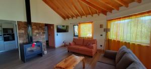 a living room with a couch and a tv at Cá du Mattu in Villa Pehuenia +53 photos