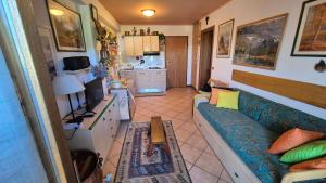 a living room with a couch and a kitchen at Le Ginestre in Faidello +28 photos