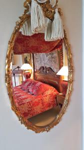 a bed in a room with a mirror and a painting on the wall at Beggar's Knap in Dorchester