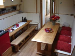 una cocina con bancos de madera y flores en una habitación en Zeilschip De Vrouw Dina en Leiden