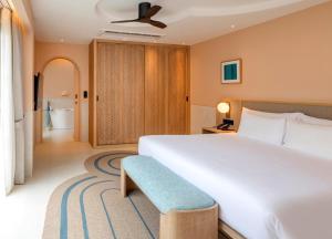 a bedroom with a large white bed and a blue bench at Centara Karon Villas Phuket in Karon Beach +154 photos
