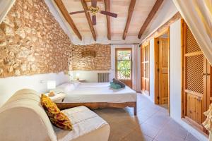a bedroom with a bed and a couch in a room at Agroturismo Sa Vall by MHR in Son Macia