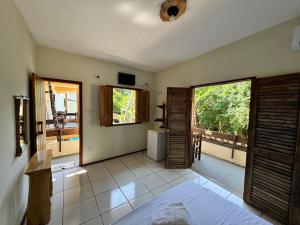 a bedroom with a bed and two windows and a balcony at Pousada Vila Verde in Olivença