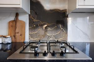 a stove top oven in a kitchen next to a counter at West London Spacious Modern House Garden Driveway in London