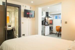 a bedroom with a bed and a kitchen in it at Studio Close To Alhambra And Bradford Live Walk To Stations in Bradford +3 photos