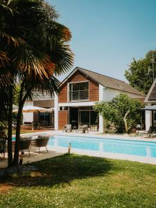 a house with a swimming pool in front of a house at Les Arbres Rouges in Sucé +71 photos